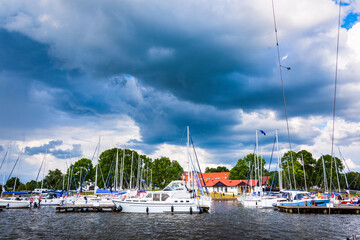 Fototapeta na wymiar Yachts moored in a harbor. Sailboats in the dock. Summer vacations