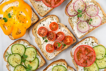 Healthy vegetarian sandwiches with vegetables - yellow pepper, tomato, cucumber and radish. Cream...