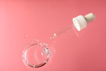 Pipette with transparent liquid - gel, serum or essential oil in water on pink. Moisturizing, refreshing concept