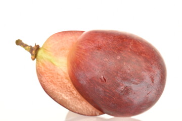 Two halves of fresh organic, juicy, ripe, sweet grapes, close-up, on a white background.