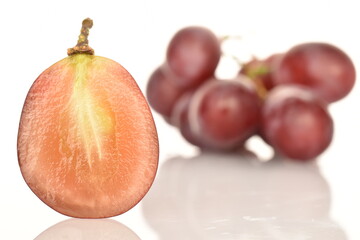 One half, natural, organic, sweet and sour grapes, in focus, macro. In the background is a bunch of grapes. The background is white.