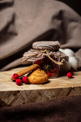 Knife lies next to bread and a jar of biscuits on a brown background