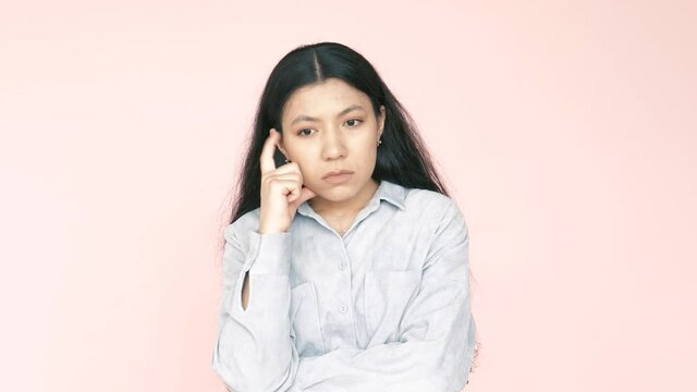 Hmm, need to think. Have an idea. Doubtful hispanic female thinking hesitating making choice. Indoor studio shot isolated on pink background