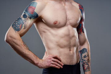 Naklejka premium sporty man with a pumped-up torso tattoo on his arms cropped view model