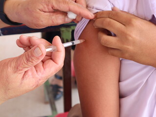 closeup of the doctor injecting the patient with the syringe in the hospital.