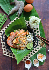 Pad Thai - Famous Thai Stir fried noodles with shrimp and some ingredients on the banana leaf - Flat lay , Vertical view