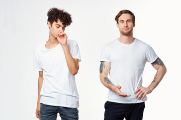 two men in white t-shirts stand side by side cropped view studio 