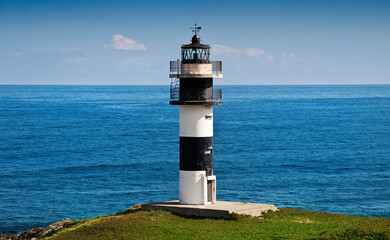 View of the Pancha Island Lighthouse in Ribadeo, Galicia. With the blue sea in the background.