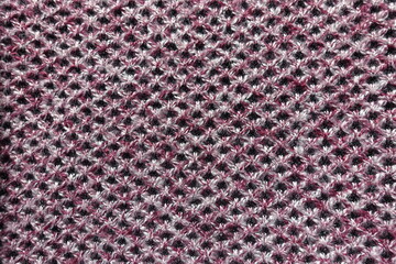 View of thick pink, grey and white woolen fabric with diamonds pattern from above