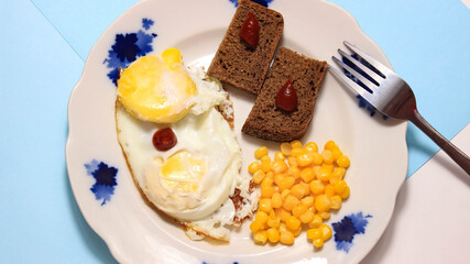 A dish with fried egg, corn and bread on a plate, where all the ingredients gradually appear.