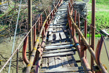 Rickety bridge for pedestrian passing across the river . Trekking with adventure