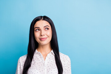 Photo of dreamy happy young nice lady look empty space imagine plan smile isolated on blue color background