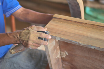 Closeup of hand of woodworker using sandpaper to sand a wooden chair while working in his woodworking shop, Sandpaper, Table Leg, Plant, Carpenter, Old Wood Surface