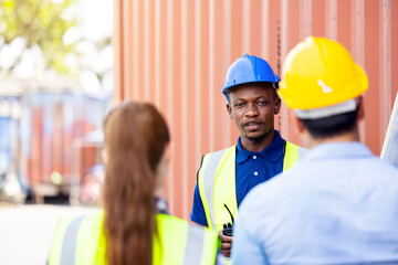 Outdoor shot of black African engineer inspect electrical solar panel wearing hardhat, protective...