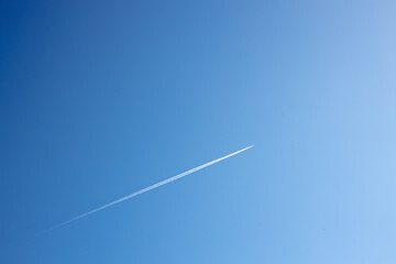 fighter in flight in the air, white reversing trail of the aircraft in the blue sky, a supersonic fighter in flight