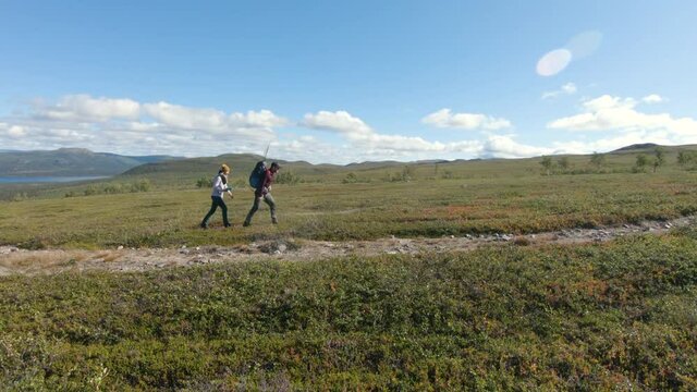Man and woman hiking in the beautiful nature of Saltoluokta, Northern Sweden.