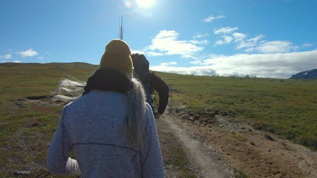 Close-up of a male and female hiker. Walking in the beautiful nature of Saltoluokta, Northern Sweden, on a sunny day.