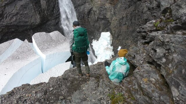 Male and female hiker at the famous waterfall, Silverfallet, Northern Sweden.
