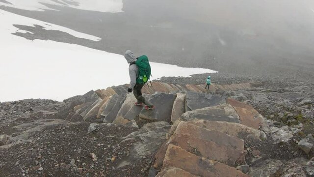 Male and female hiker walking down the famous big rock step stairs built by Sherpas Nepal. On their way down the Kebnekaise mountain.