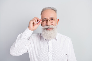 Fototapeta premium Photo of handsome cheerful grey hair old man touch spectacles wear white shirt isolated on grey color background