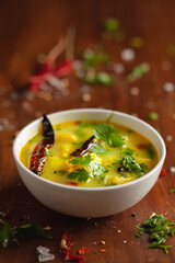 close-up of healthy curry of yogurt and potato (Dahi Aloo or Aaloo ) an Indian Classical dish. Served in a white ceramic bowl. Over Wooden Background. Top view 