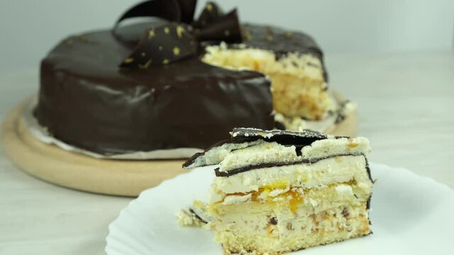 The process of eating a cake. A piece of cake on a plate. Enjoy the taste and eat delicious cake. Hand in a black disposable glove during the process of eating cake with a spoon.