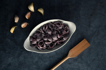 Dark Food Photography Pasta on white dish, dark background, text space.