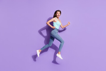 Fototapeta na wymiar Full size profile photo of astonished attractive lady running open mouth look camera isolated on violet color background