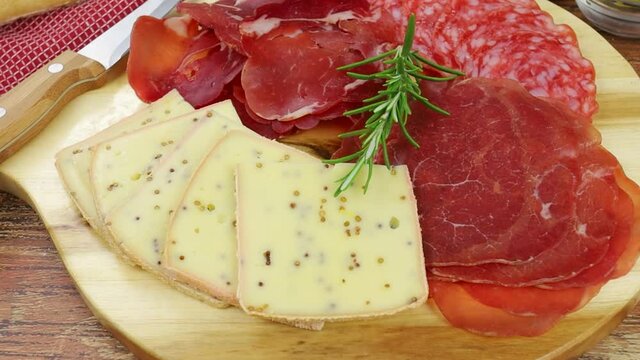 fromage &agrave; raclette et charcuterie sur une planche &agrave; d&eacute;couper