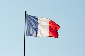 Drapeau français au vent sous un ciel bleu