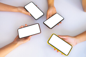 Close up of people’s hands using smartphone with white mockup screens. Mockup picture