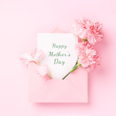 Happy Mother's Day card in pink envelope with carnations on pink background. - obrazy, fototapety, plakaty