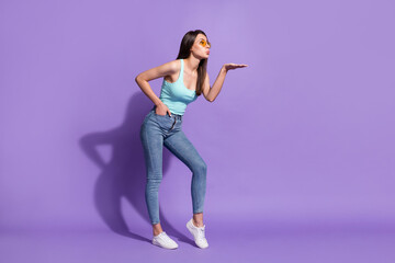 Full length body size photo of girl sending air kiss to blank space isolated on pastel purple color background