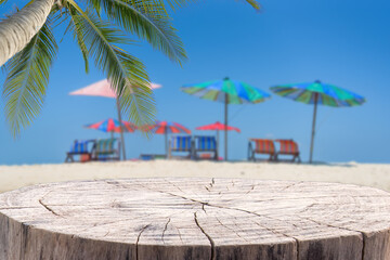 Wooden desk or stump on sand beach in summer. background. For product display.