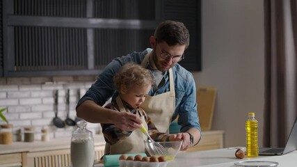 man and little boy are whipping eggs for omelet, father is learning son to cook at home kitchen, spending time together - Powered by Adobe