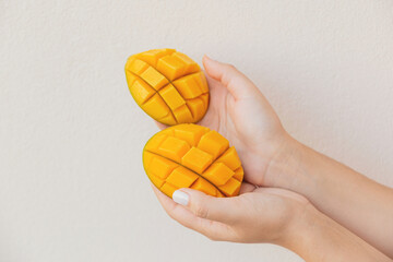 Beautiful slices of chopped mango in female hands. Vegan healthy dessert. High quality photo