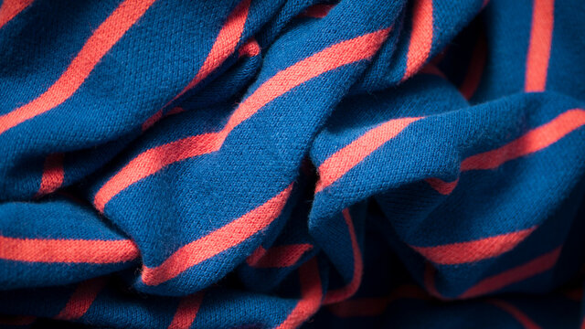 Camiseta polo azul con rayas rojas arrugada