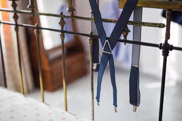 Tirantes de ropa para un novio preparados colgados en la cama par avestirse