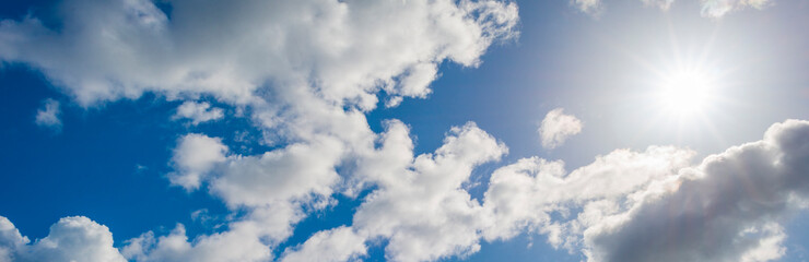 Obraz premium Grey white cumulus clouds in a blue sky in bright sunlight in spring, Almere, Flevoland, The Netherlands, April 13, 2021