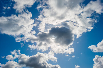 Grey white cumulus clouds in a blue sky in bright sunlight in spring, Almere, Flevoland, The Netherlands, April 13, 2021