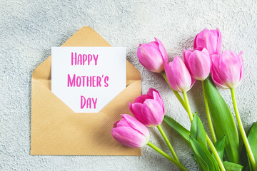 Mother's day Holiday Concept. Pink tulips, greeting card on concrete background. Flat lay, top view
