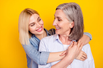 Photo portrait of mother and daughter cuddling together smiling isolated bright yellow color background