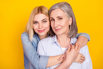 Photo portrait of daughter hugging her mum smiling wearing casual outfit isolated bright yellow...