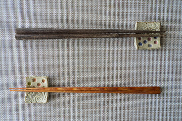 Two chopsticks for male and female are placed on chopstick rest with different direction. It might...