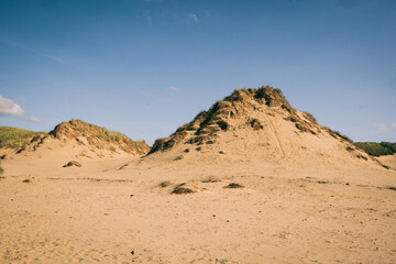 Rocky sand dunes against a blue sky
