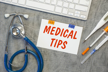 Paper with Medical Tips on a table, stethoscope and pills