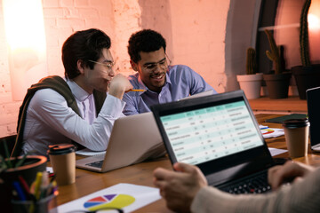 Colleagues working together in modern office using devices and gadgets during creative meeting