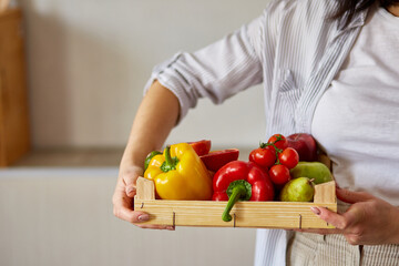 Woman holding wooden box with natural fresh vegetables and fruits for cooking. Bio organic food, healthy eating, Shopping, grocery store. Diet and vegetarian concept. .