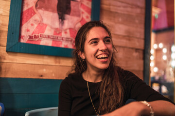 Closeup of a happy laughing Spanish girl resting in a caf