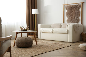 Comfortable sofa and hanging faux fur in modern room. Interior design